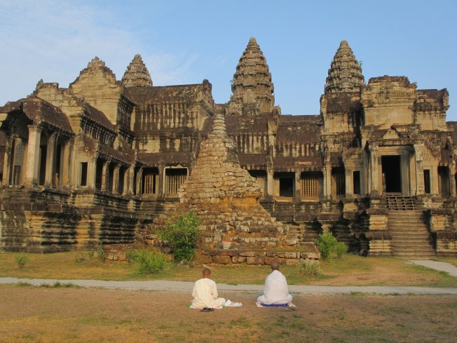 Angkor Wat ve önünde ibadet eden budist keşişler Angkor Wat ve önünde ibadet eden budist keşişler