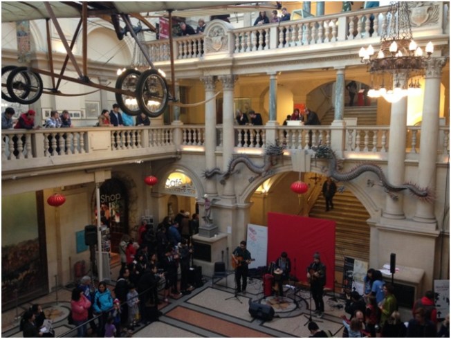 Bristol Müzesi – Çin yeni yılı Kutlamaları Sırasında / Müzisyenlerin solunda duran kafasına kova geçirilmiş heykel Banksy.